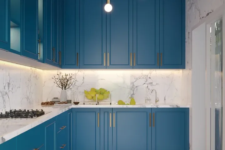 A kitchen with blue cabinets and marble counters